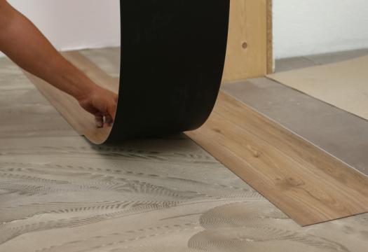 Worker installing new vinyl tile floor | Merry Maids