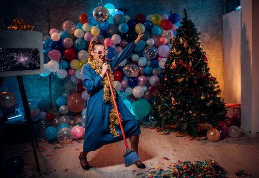 Young woman dancing and cleaning after new year party | Merry Maids