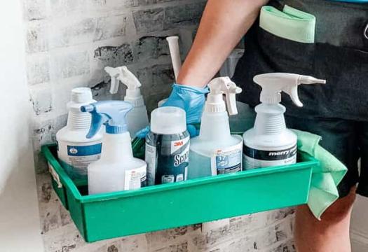 A person holding cleaning supplies
