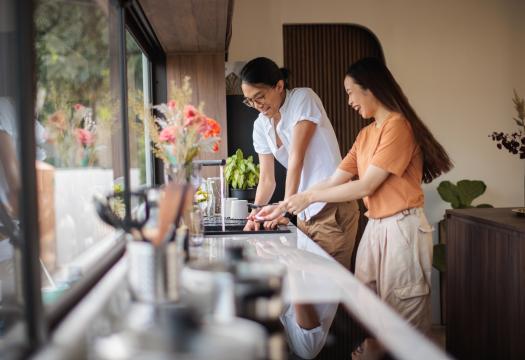 Young couple doing dishes together, laughing and enjoying a clean home. | Merry Maids®