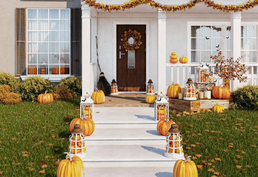 House decorated for Halloween with fall leaves in yard.